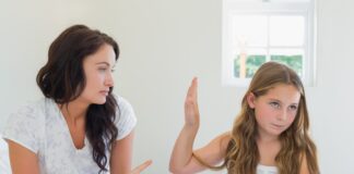 Girl Showing Stop Gesture To Angry Mother In Bed