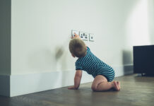 Little Baby Reaching For A Plug Socket