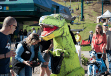 A person in a dinosaur costume at a fall festival