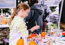 A girl painting pumpkins