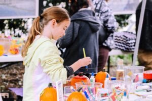 A girl painting pumpkins