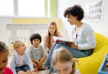 A woman reading a book to several children