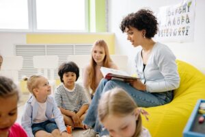 A woman reading a book to several children