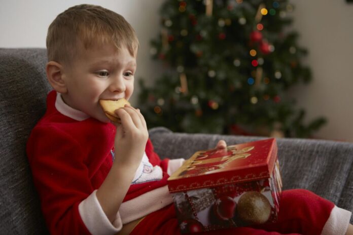 A boy eating Christmas cookies