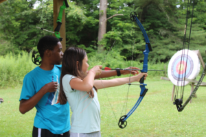 Two children at an archery course at Camp Soles