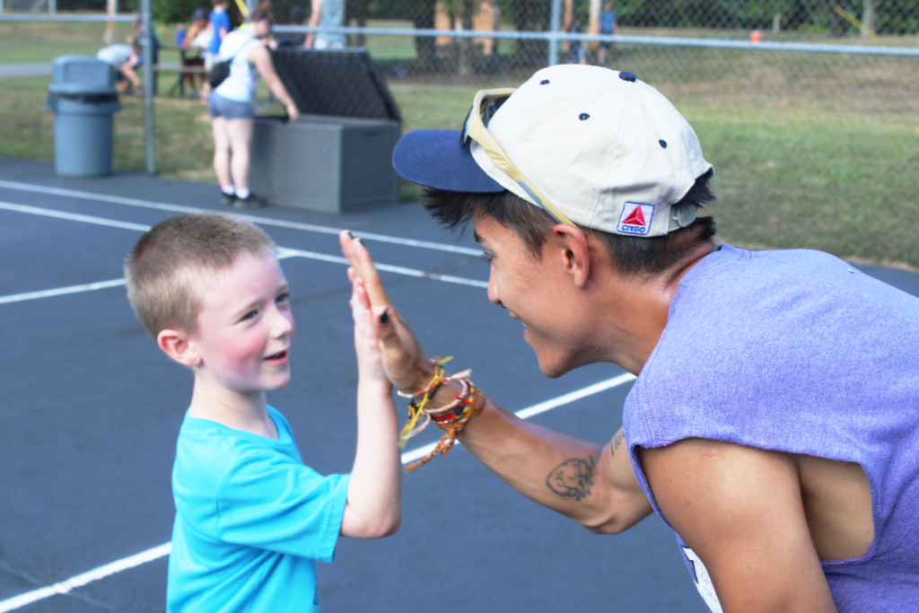 A Camp Soles counselor giving a camper a high-five