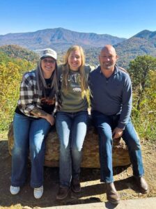 Three people sitting on a log