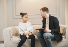 A therapist speaking to a child with a teddy bear