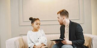 A therapist speaking to a child with a teddy bear