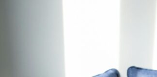 Sick person laying on a couch, blowing their nose