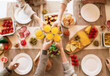 People toasting with orange juice over a brunch table