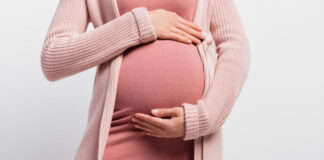panoramic crop of pregnant woman touching belly isolated on white