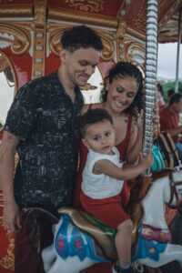 A young boy and his parents ride a carousel