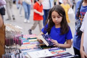 Girl looking at a book at a book fair
