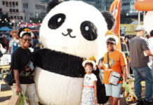 A family poses with a panda mascot